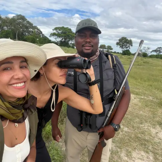 Two guests and their armed walking guide on a bush walk